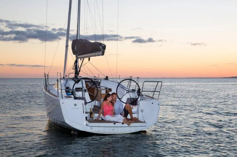 Slide: The Image of 2024 Jeanneau Sun Odyssey 349 sailboat at sunset with couple relaxing on deck. - 11