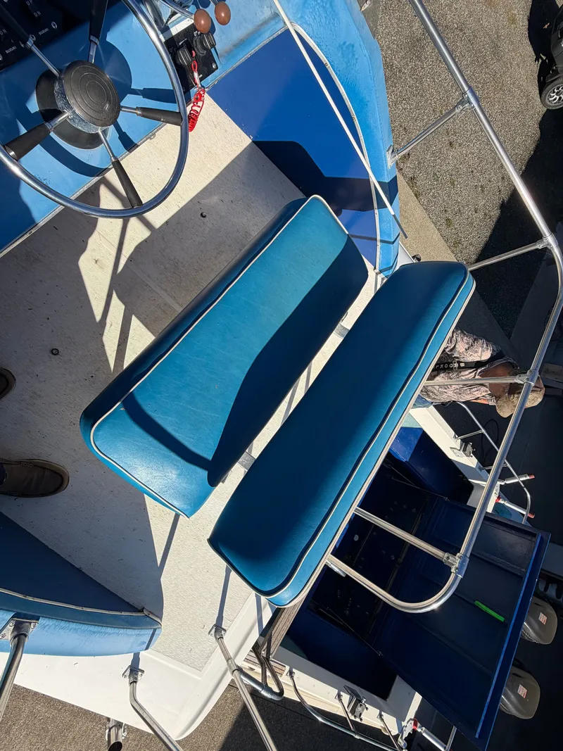Slide: The Image of The image shows a boat's helm with blue seats and a steering wheel. - 28