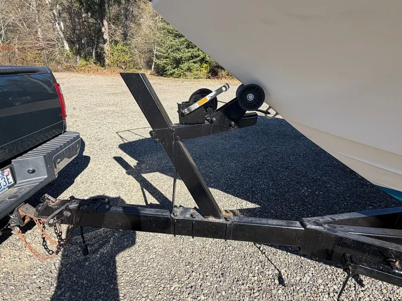 Slide: The Image of A boat on a trailer hitched to a vehicle, parked on a gravel lot. - 7