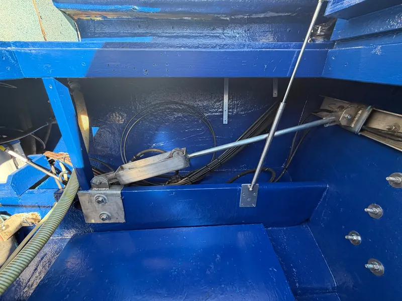Slide: The Image of View of a boat's engine compartment with blue paint, visible cables, and metal rods. - 16