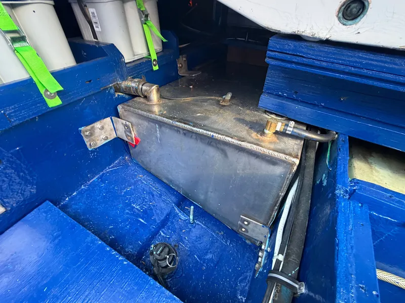 Slide: The Image of A blue engine compartment with a metal tank and batteries secured with green straps. - 19