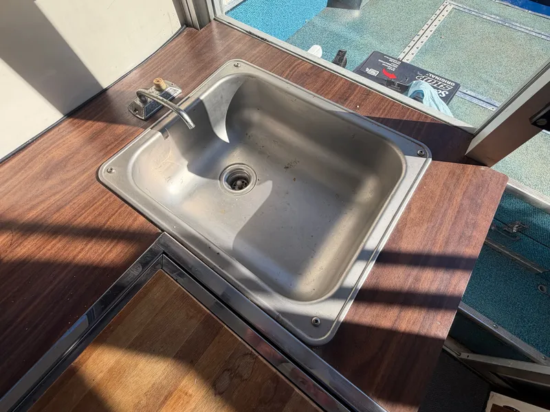 Slide: The Image of A stainless steel sink is set into a wooden countertop, surrounded by blue carpet flooring. - 30