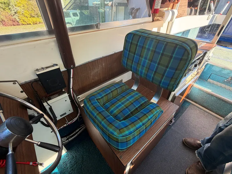 Slide: The Image of Interior of a boat with a blue-green plaid seat and wood paneling. - 34