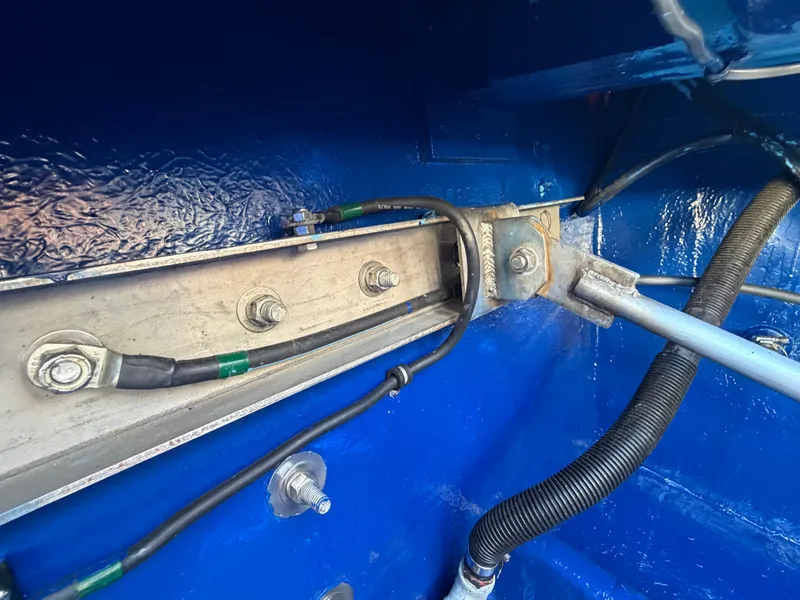 Slide: The Image of Close-up of a blue engine compartment with cables and metal components. - 22