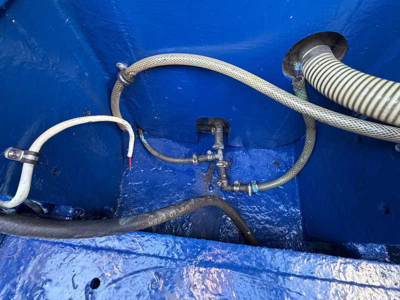 Slide: The Image of A blue-painted engine compartment with hoses and valves. - 24
