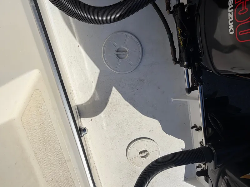 Slide: The Image of The image shows the engine area of a boat with a Suzuki motor and hoses. - 12