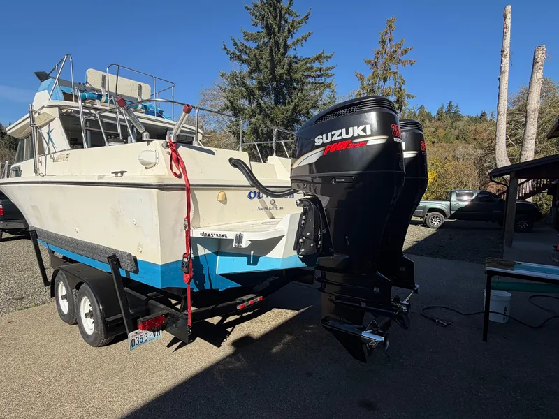 The Image of A 1974 Fiberform Sportfisher 31 on a trailer with a Suzuki outboard motor. - 0