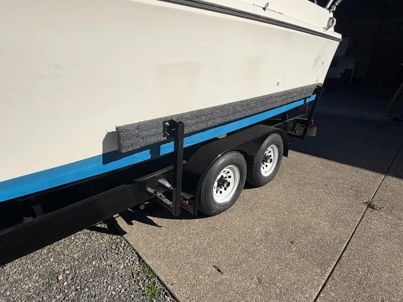 Slide: The Image of A boat on a trailer with two white wheels, parked on a concrete surface. - 8
