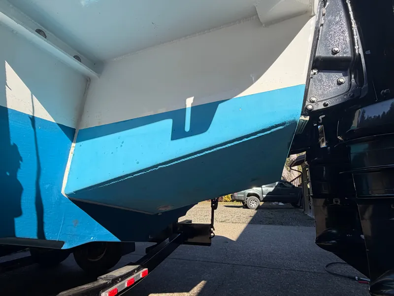 Slide: The Image of The image shows the hull of a boat with blue and white paint on a trailer. - 10