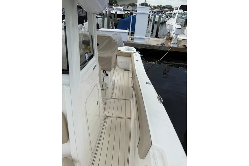 Slide: The Image of 2022 NauticStar 28 XS boat docked at marina, showcasing sleek deck design. - 30