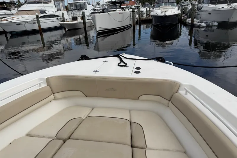 Slide: The Image of 2022 NauticStar 28 XS boat interior with beige seating, docked among other boats. - 16