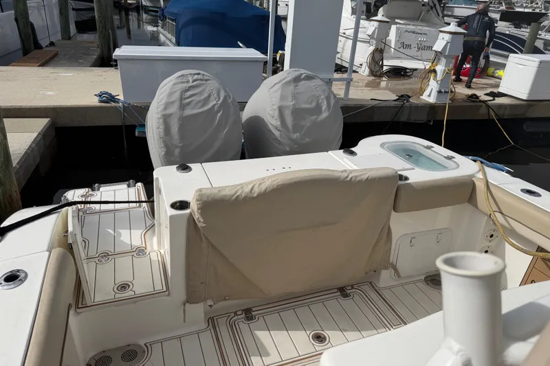 Slide: The Image of 2022 NauticStar 28 XS boat interior at dock, featuring covered seats and deck. - 8
