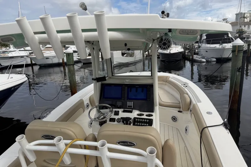 Slide: The Image of 2022 NauticStar 28 XS boat interior with helm, docked at marina. - 53