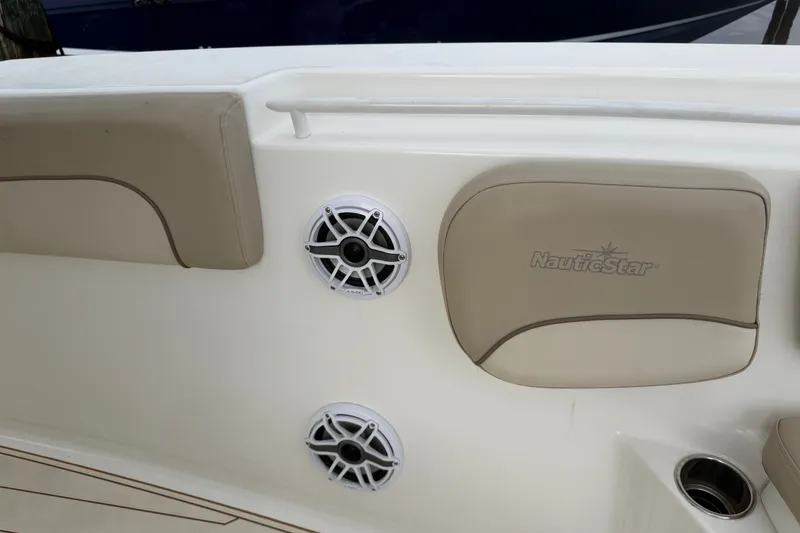 Slide: The Image of 2022 NauticStar 28 XS boat interior with speakers and cushioned seating. - 19