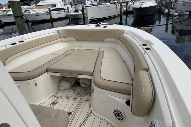 Slide: The Image of 2022 NauticStar 28 XS boat interior with beige seating, docked at marina. - 15