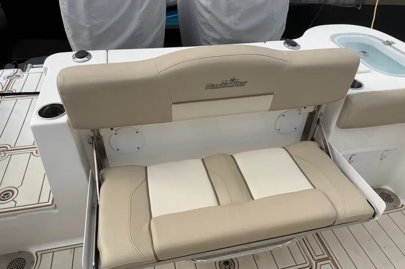 Slide: The Image of 2022 NauticStar 28 XS boat seat with beige upholstery and cup holders. - 32