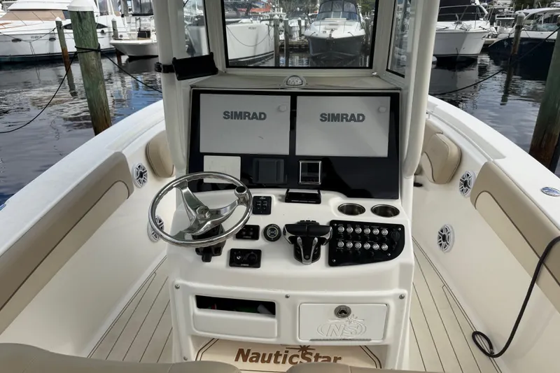 Slide: The Image of 2022 NauticStar 28 XS boat cockpit with dual Simrad displays and steering wheel. - 34