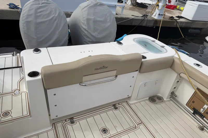 Slide: The Image of 2022 NauticStar 28 XS boat interior with seating and storage at dock. - 31