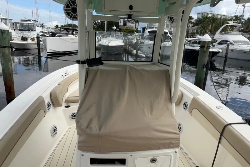Slide: The Image of 2022 NauticStar 28 XS boat docked at marina with covered console. - 12