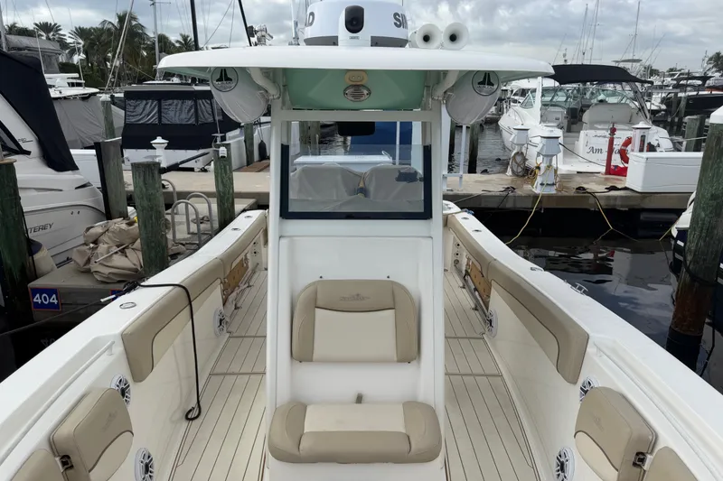 Slide: The Image of 2022 NauticStar 28 XS boat docked at marina, featuring beige seating and modern design. - 26