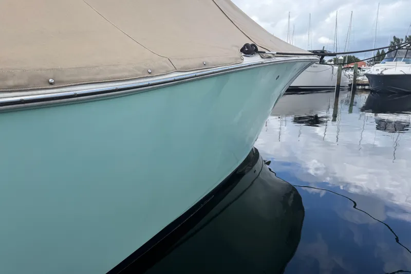 Slide: The Image of 2022 NauticStar 28 XS boat docked in calm marina waters. - 61