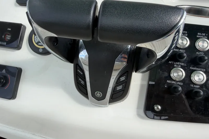 Slide: The Image of Control panel of a 2022 NauticStar 28 XS boat with throttle and switches. - 36