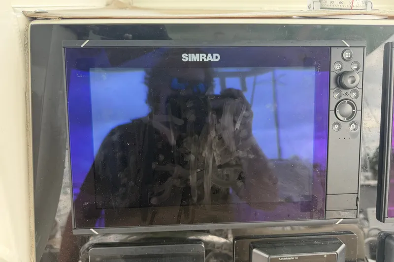 Slide: The Image of Simrad display on 2022 NauticStar 28 XS boat dashboard with reflection. - 45
