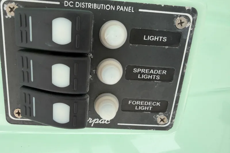 Slide: The Image of DC distribution panel on 2022 NauticStar 28 XS boat with light switches. - 38