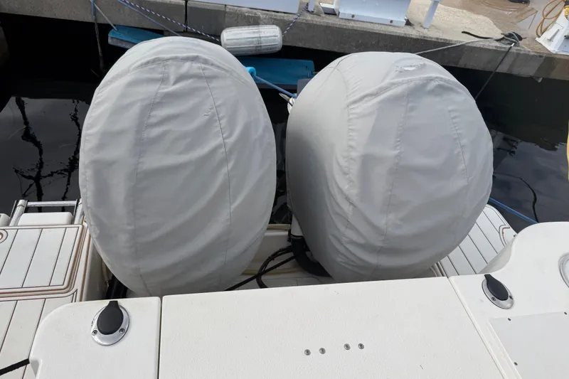 Slide: The Image of Covered outboard motors on a 2022 NauticStar 28 XS boat at a dock. - 33