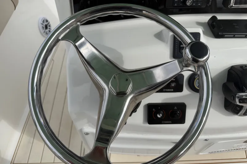 Slide: The Image of Steering wheel of 2022 NauticStar 28 XS boat, featuring modern controls and dashboard. - 42
