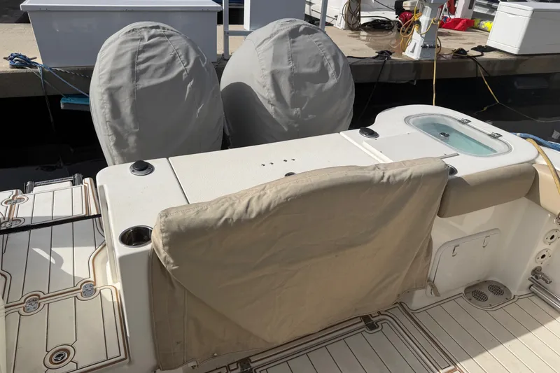 Slide: The Image of 2022 NauticStar 28 XS boat with covered engines and deck, docked at marina. - 3