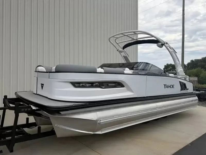 Slide: The Image of A modern pontoon boat with a curved canopy and sleek lines, parked on a trailer. - 17
