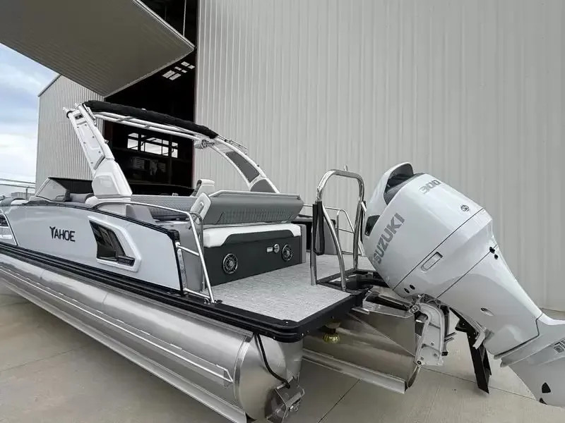 Slide: The Image of 2027 Tahoe Grand 25 Flex Lounge Windshield with Suzuki outboard motor, docked at a pier. - 25