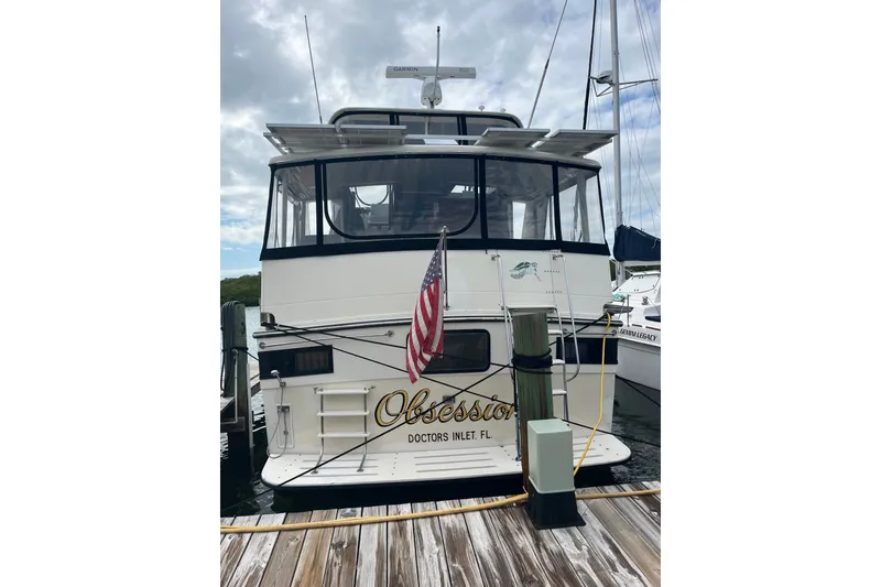 Slide: The Image of 1989 Californian 45 Motor Yacht docked, rear view with American flag and marina setting. - 2