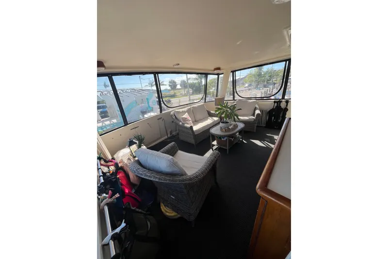 Slide: The Image of Interior of 1989 Californian 45 Motor Yacht with wicker seating and large windows. - 11