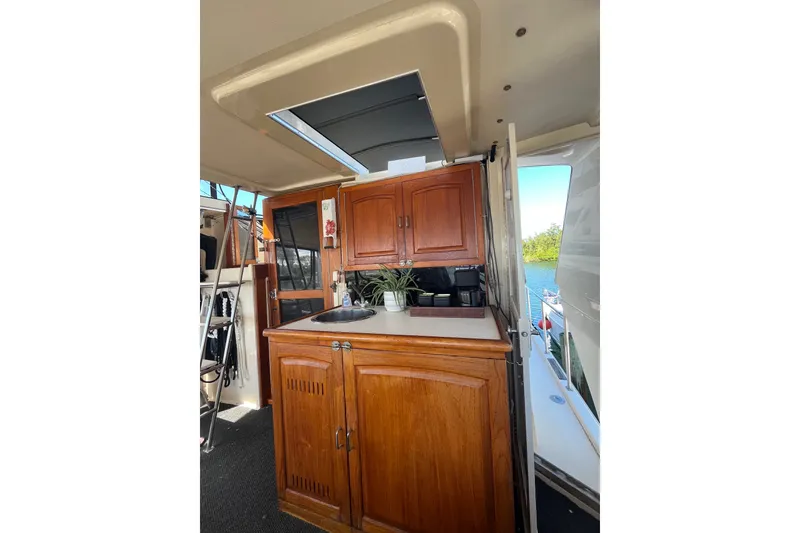 Slide: The Image of 1989 Californian 45 Motor Yacht interior with wooden cabinetry and countertop, featuring a sink and potted plant. - 14