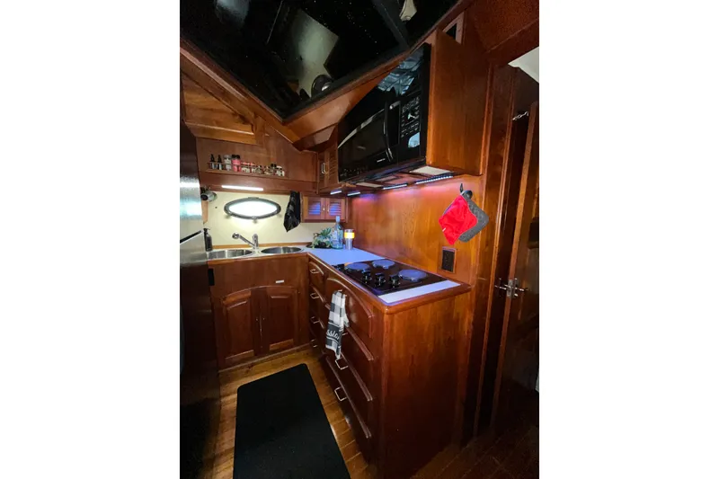 Slide: The Image of Cozy kitchen interior of 1989 Californian 45 Motor Yacht with wooden cabinetry and modern appliances. - 25