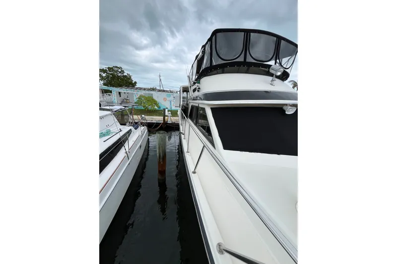 Slide: The Image of 1989 Californian 45 Motor Yacht docked beside another boat under cloudy skies. - 10