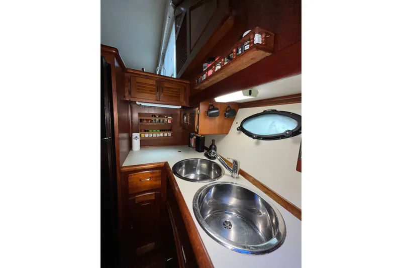 Slide: The Image of Interior of 1989 Californian 45 Motor Yacht kitchen with dual sinks and wooden cabinetry. - 26