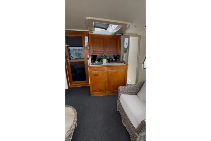 Slide: The Image of Interior of 1989 Californian 45 Motor Yacht with wooden cabinetry and wicker seating. - 13