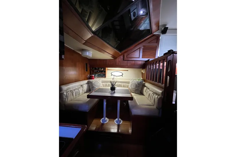 Slide: The Image of Interior of 1989 Californian 45 Motor Yacht with cozy dining area and wooden accents. - 21