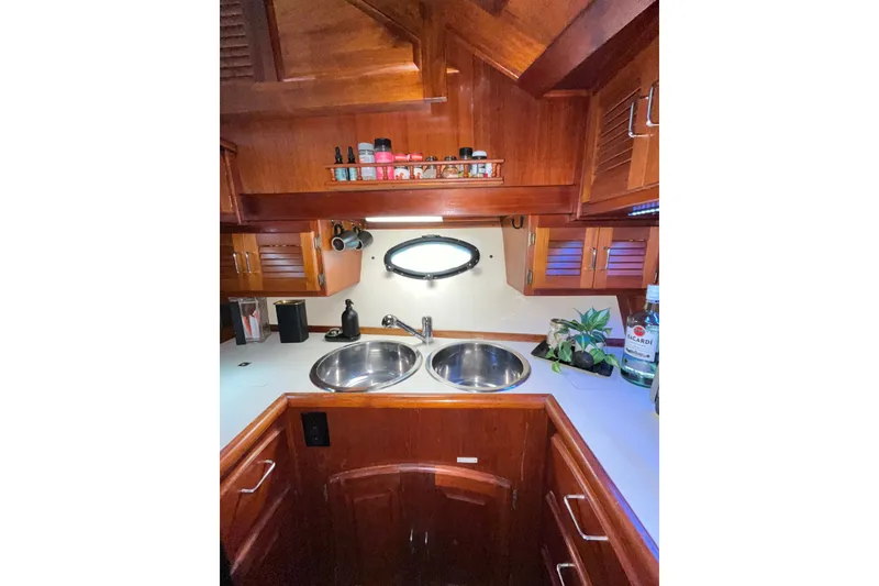 Slide: The Image of Wooden yacht kitchen with dual sinks, porthole, and storage. Californian 45 Motor Yacht, 1989. - 24