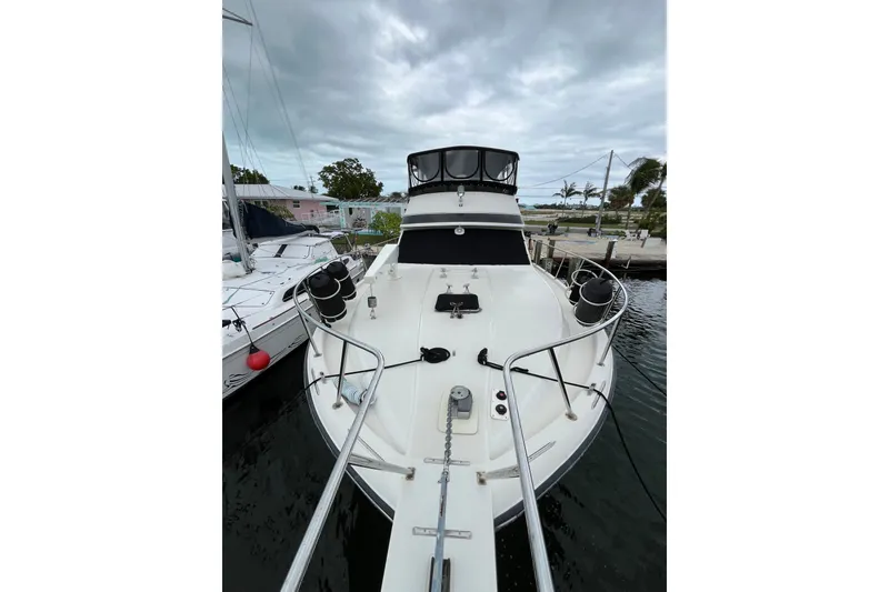 Slide: The Image of 1989 Californian 45 Motor Yacht docked, showcasing sleek design and spacious deck. - 8