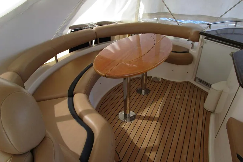 Slide: The Image of Luxurious Neptunus 56 Flybridge 2006 yacht interior with curved seating and wooden table. - 64