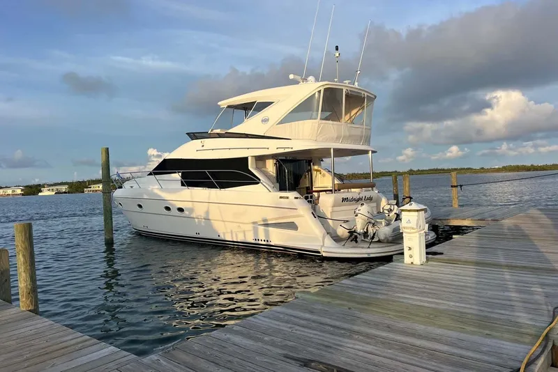 Slide: The Image of 2006 Neptunus 56 Flybridge yacht docked at a marina under a cloudy sky. - 81