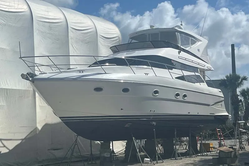 Slide: The Image of 2006 Neptunus 56 Flybridge yacht on dry dock under a cloudy sky. - 87