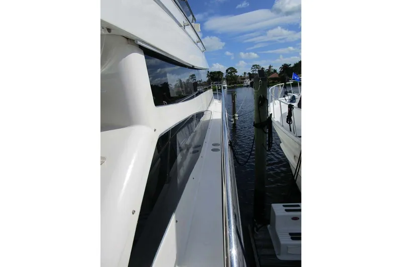 Slide: The Image of 2006 Neptunus 56 Flybridge yacht docked, showcasing sleek design and waterfront view. - 42