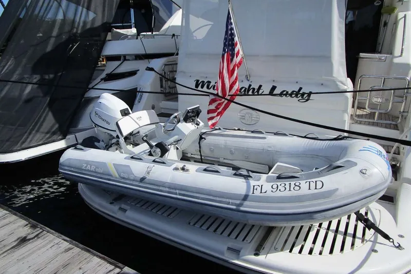 Slide: The Image of A 2006 Neptunus 56 Flybridge yacht with an inflatable dinghy and American flag. - 82
