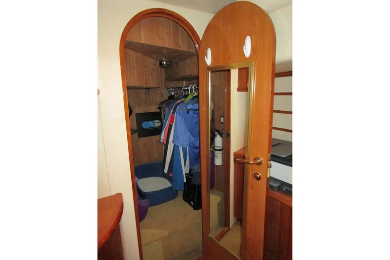 Slide: The Image of Wooden closet interior on 2006 Neptunus 56 Flybridge yacht with hanging clothes. - 23