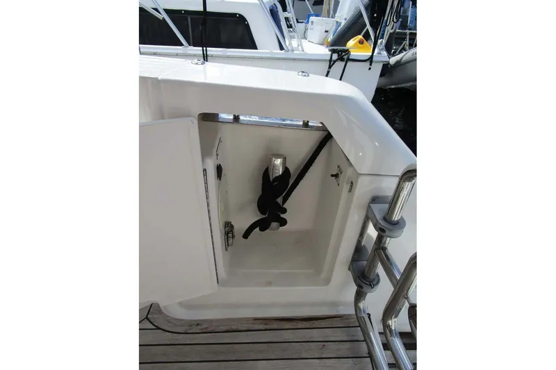 Slide: The Image of Open storage compartment on 2006 Neptunus 56 Flybridge yacht, featuring a secured black hose. - 47